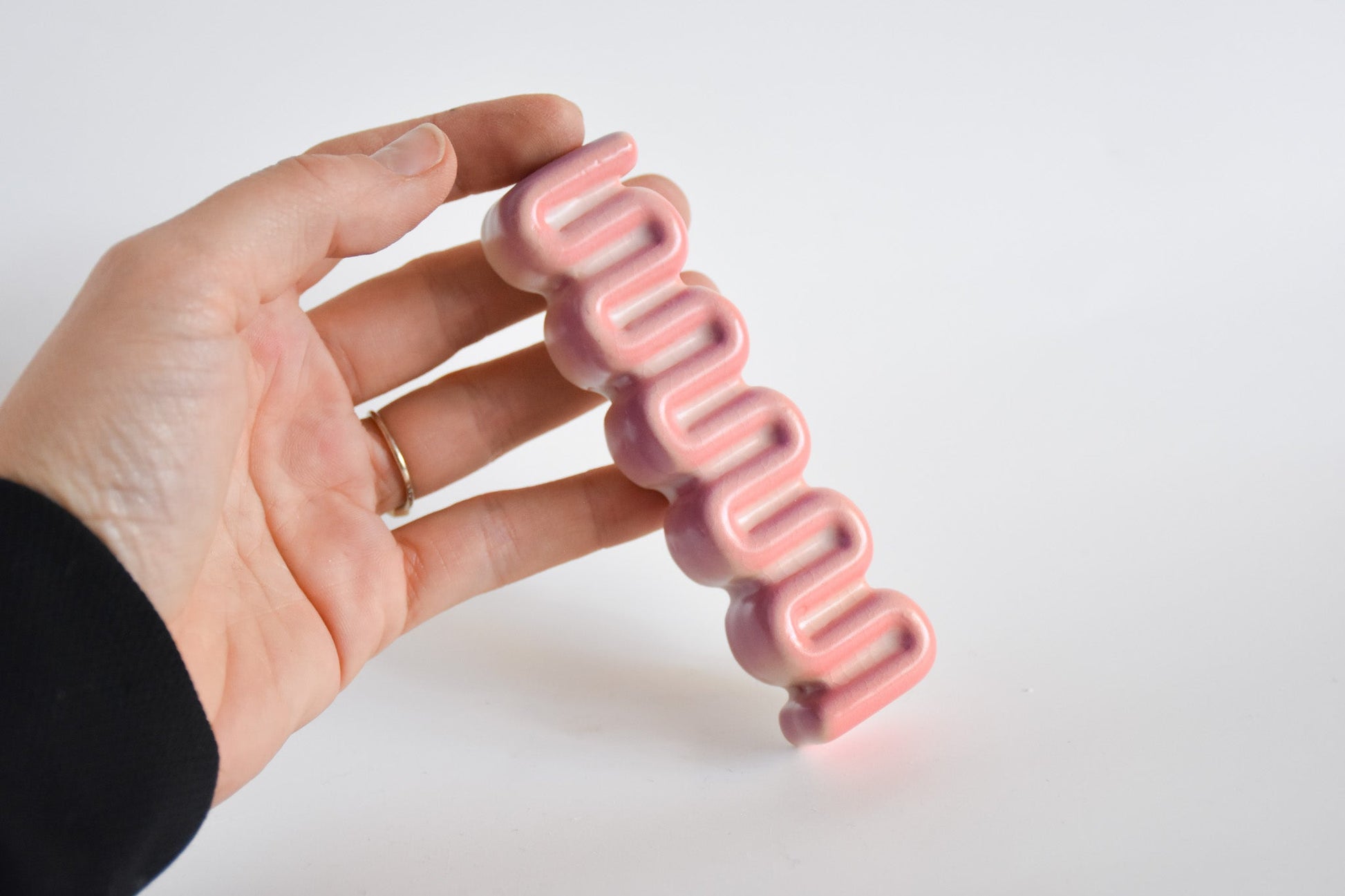 Handmade ceramic mezuzah titled 'Ribbon Mezuzah - Flamingo Fade' – modern Judaica by Feldi Studios