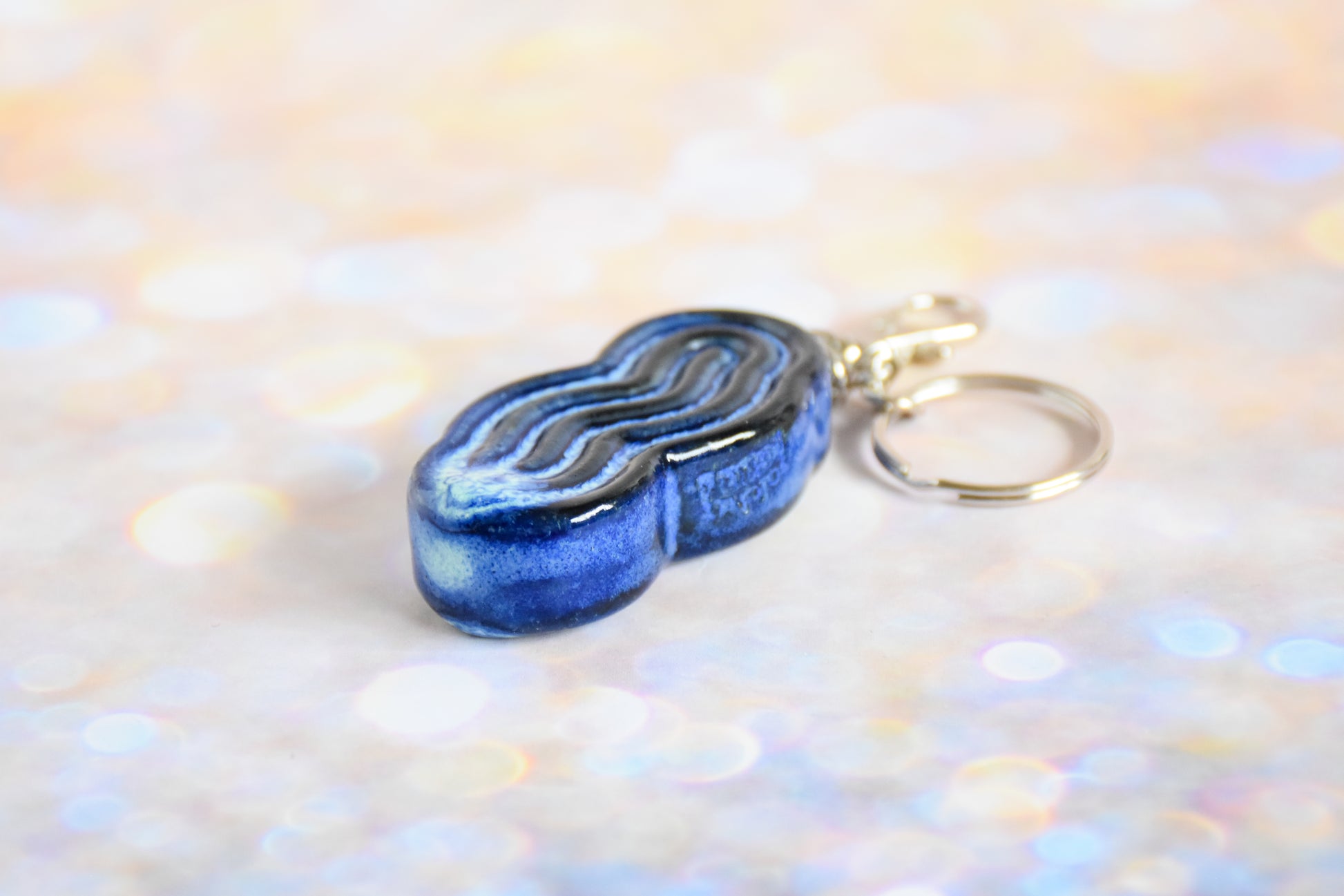 Handmade ceramic accessory titled 'Squigglet Fidget Charm Keychain - Blue' – modern Judaica by Feldi Studios