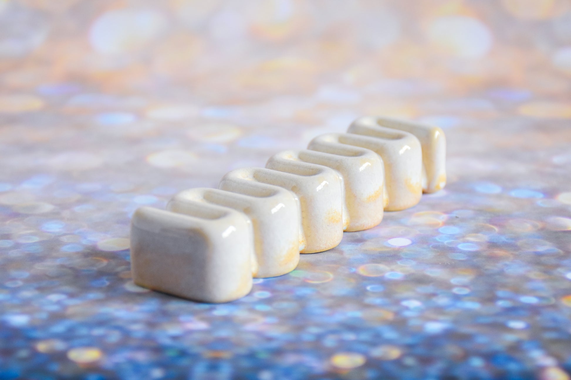 Handmade ceramic mezuzah titled 'Ribbon Mezuzah - Cream' – modern Judaica by Feldi Studios