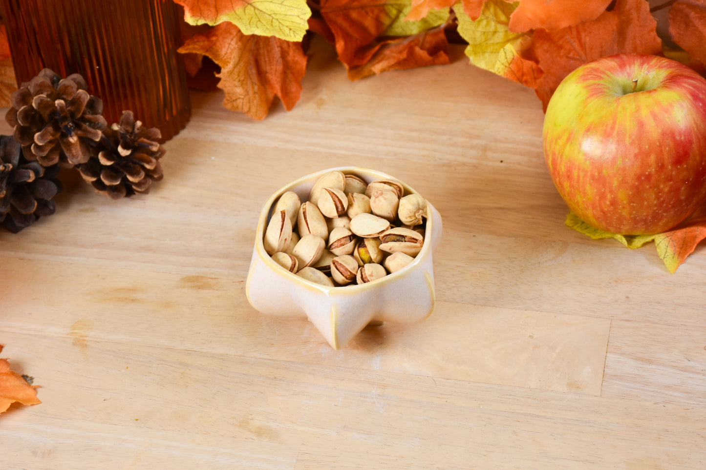 Pom honey pot filled with nuts showing versatility of product.